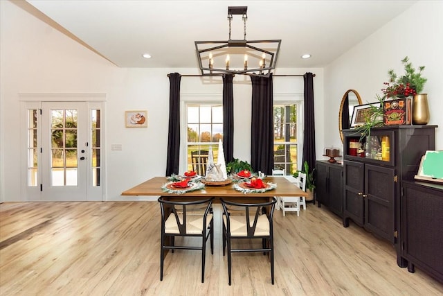 dining space featuring an inviting chandelier, a wealth of natural light, and light hardwood / wood-style flooring