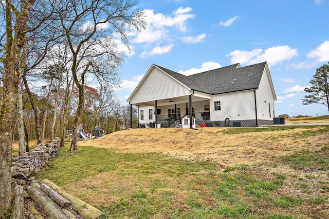 rear view of house featuring ceiling fan, a yard, and central AC unit