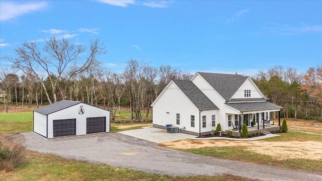 view of front of property with an outbuilding, a front yard, a porch, and a garage