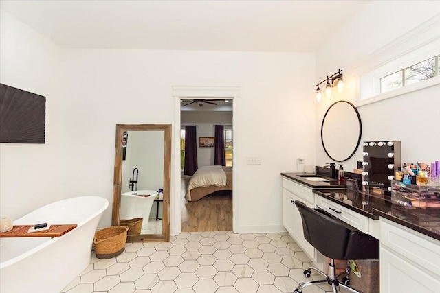 bathroom featuring a washtub, hardwood / wood-style floors, vanity, and ceiling fan