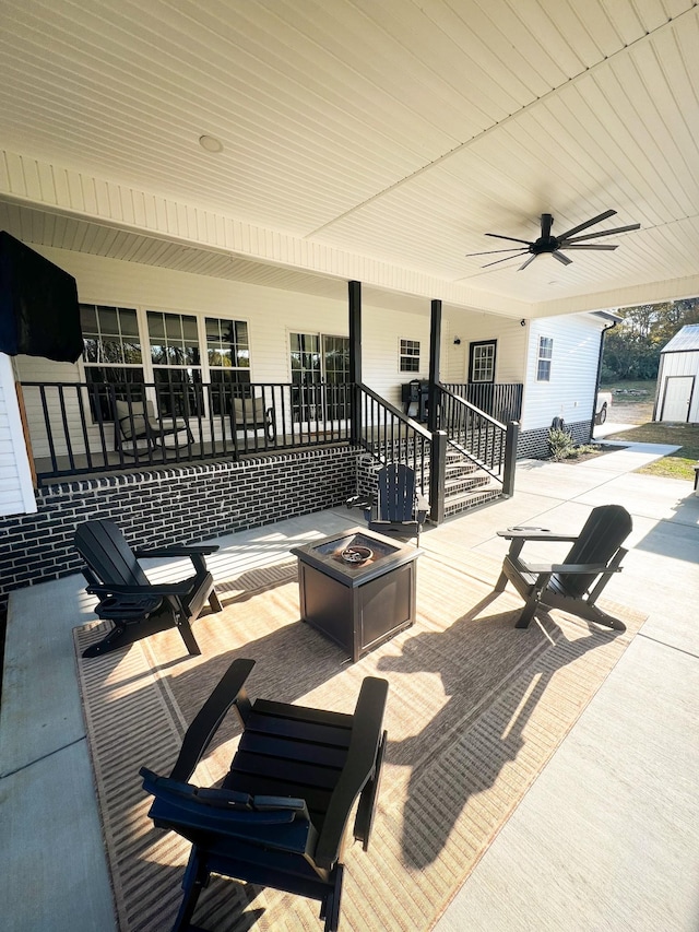 view of patio / terrace featuring a fire pit, ceiling fan, and a porch