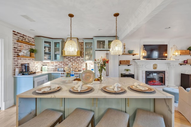 kitchen featuring decorative light fixtures, a breakfast bar, and light hardwood / wood-style flooring