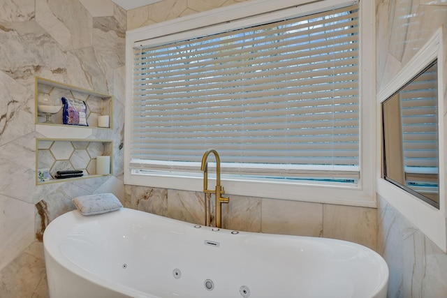 bathroom with a washtub, a healthy amount of sunlight, and tile walls