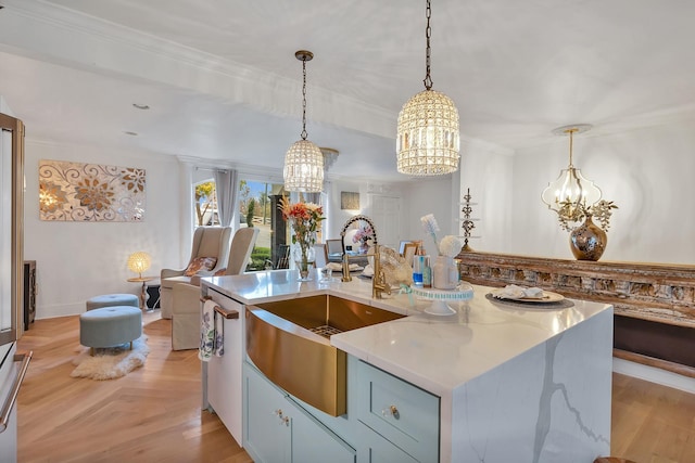 kitchen with a center island with sink, decorative light fixtures, light stone counters, and a chandelier