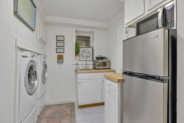 laundry area with independent washer and dryer, crown molding, and sink