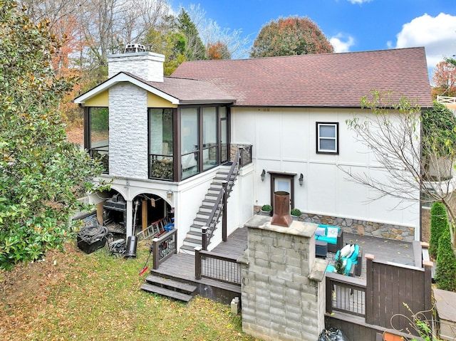 rear view of property with a wooden deck and a sunroom