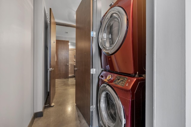 clothes washing area featuring stacked washer and clothes dryer