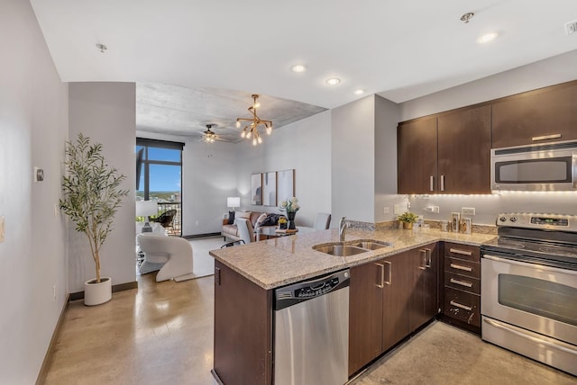 kitchen featuring light stone countertops, ceiling fan, sink, stainless steel appliances, and kitchen peninsula