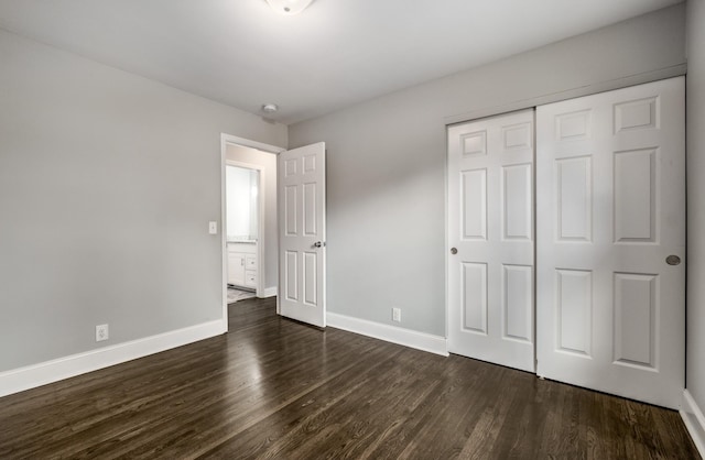 unfurnished bedroom featuring dark hardwood / wood-style flooring and a closet