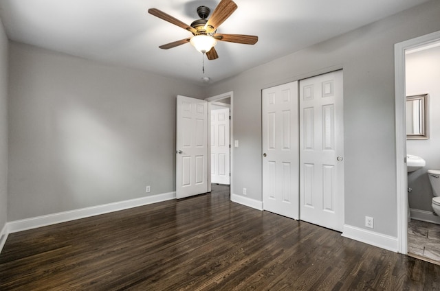 unfurnished bedroom featuring ensuite bathroom, ceiling fan, dark hardwood / wood-style flooring, and a closet