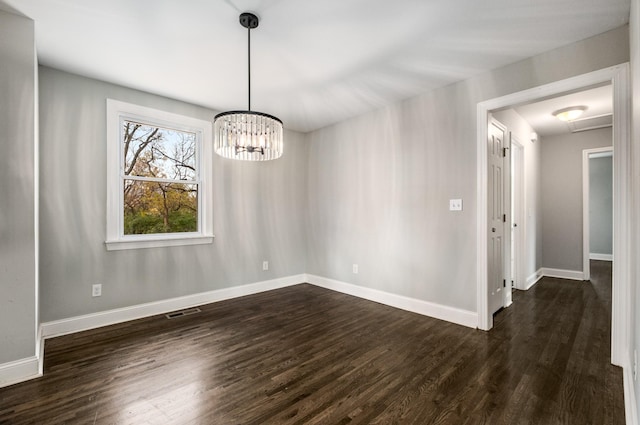 unfurnished dining area with dark hardwood / wood-style flooring and a chandelier