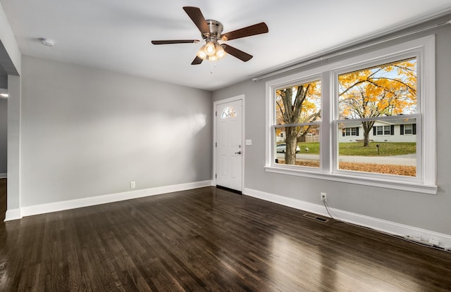 spare room with ceiling fan and dark wood-type flooring