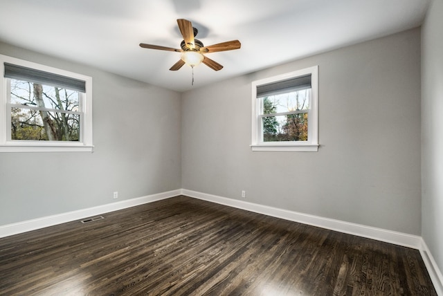 unfurnished room featuring dark hardwood / wood-style flooring, ceiling fan, and a healthy amount of sunlight