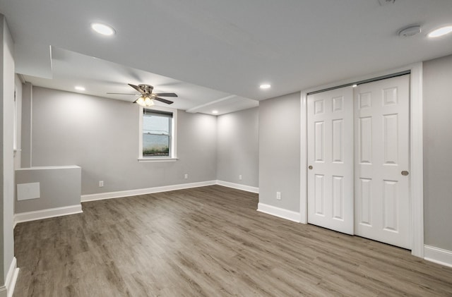 basement featuring hardwood / wood-style flooring and ceiling fan