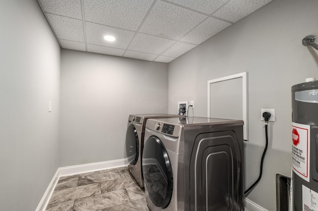 clothes washing area featuring water heater and washer and clothes dryer