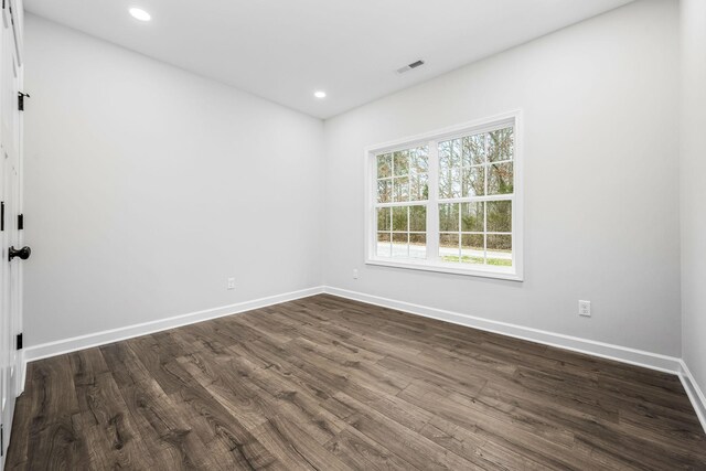 spare room with visible vents, recessed lighting, baseboards, and dark wood-style flooring