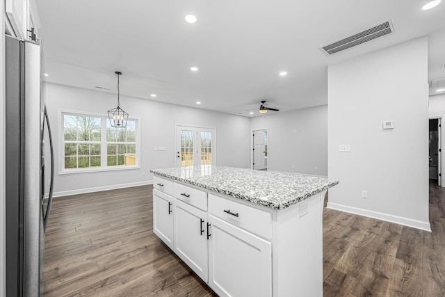 kitchen with visible vents, dark wood-type flooring, light stone counters, recessed lighting, and freestanding refrigerator