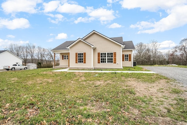 rear view of property featuring an outdoor structure, a storage shed, and a yard