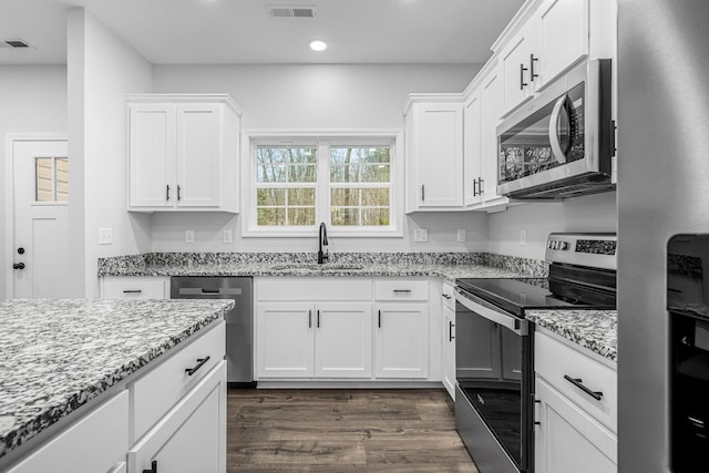 kitchen featuring visible vents, appliances with stainless steel finishes, dark wood-type flooring, and a sink