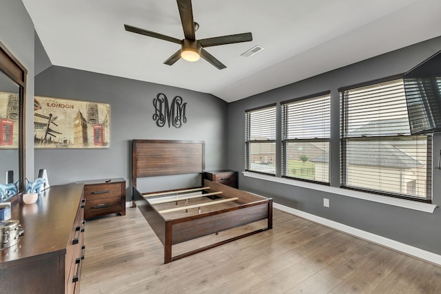 bedroom with ceiling fan, vaulted ceiling, and light hardwood / wood-style flooring