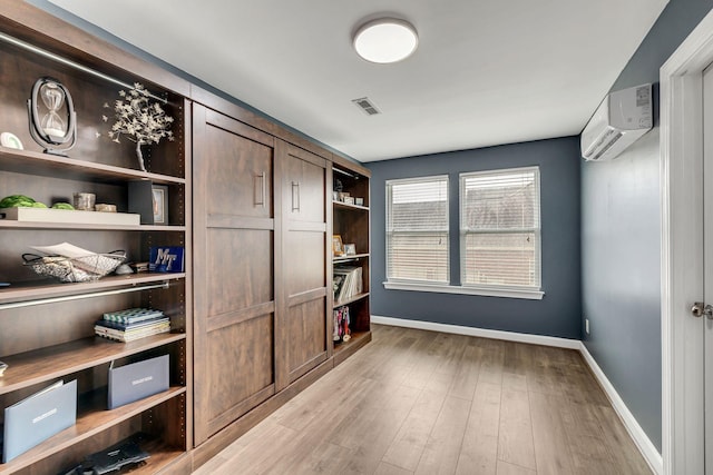 office space with light hardwood / wood-style floors and a wall mounted AC