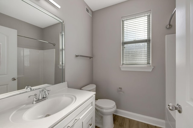 bathroom with toilet, hardwood / wood-style flooring, and vanity