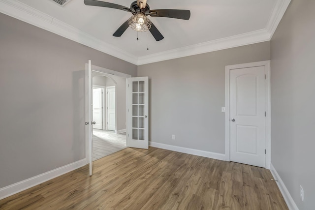 unfurnished room with french doors, ornamental molding, light hardwood / wood-style floors, and ceiling fan