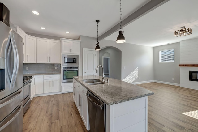 kitchen with sink, white cabinets, beamed ceiling, and appliances with stainless steel finishes