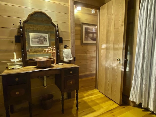 bathroom with wood walls, vanity, and hardwood / wood-style flooring