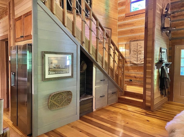 staircase with hardwood / wood-style flooring and wooden walls