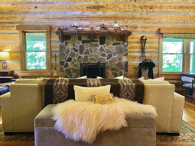 living room with a stone fireplace and hardwood / wood-style flooring