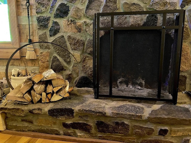 room details with hardwood / wood-style flooring and a stone fireplace