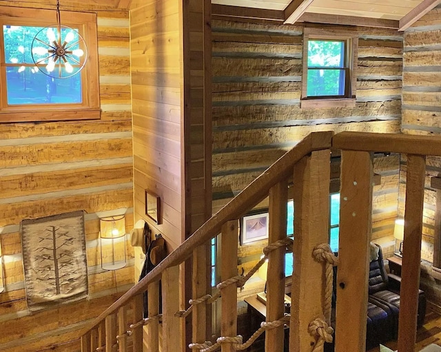 stairs with a notable chandelier and wooden walls