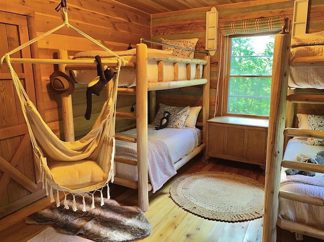 bedroom featuring hardwood / wood-style floors and wood walls