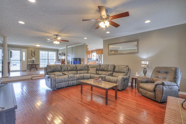 living room with a textured ceiling, wood-type flooring, and crown molding