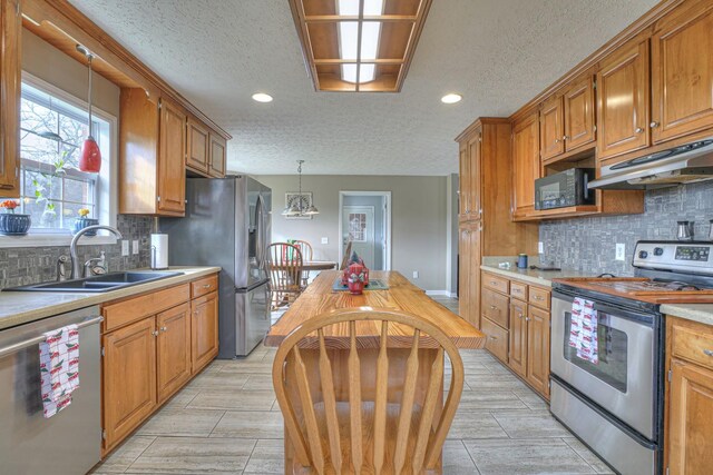 kitchen featuring a textured ceiling, sink, appliances with stainless steel finishes, and tasteful backsplash