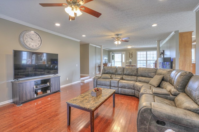 living room featuring hardwood / wood-style floors, a textured ceiling, ceiling fan, and ornamental molding