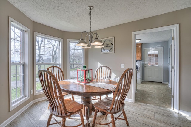 dining space with a notable chandelier, washer / dryer, and a textured ceiling