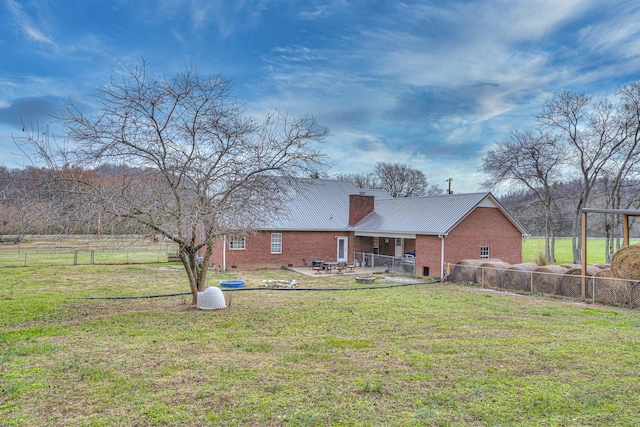 back of house featuring a lawn and a patio