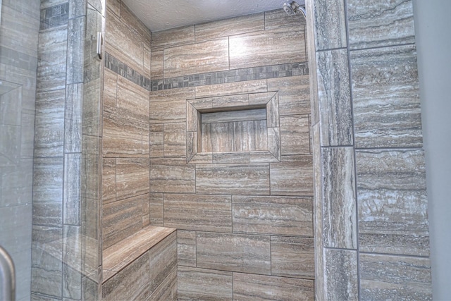 bathroom featuring a textured ceiling and walk in shower