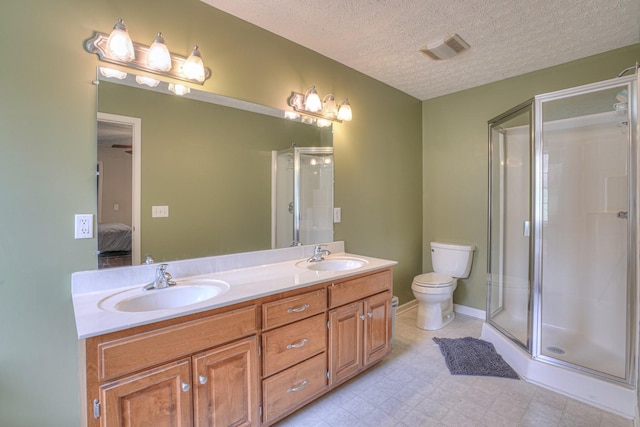 bathroom with vanity, a textured ceiling, toilet, and an enclosed shower