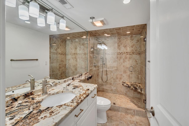 bathroom featuring vanity, toilet, and walk in shower