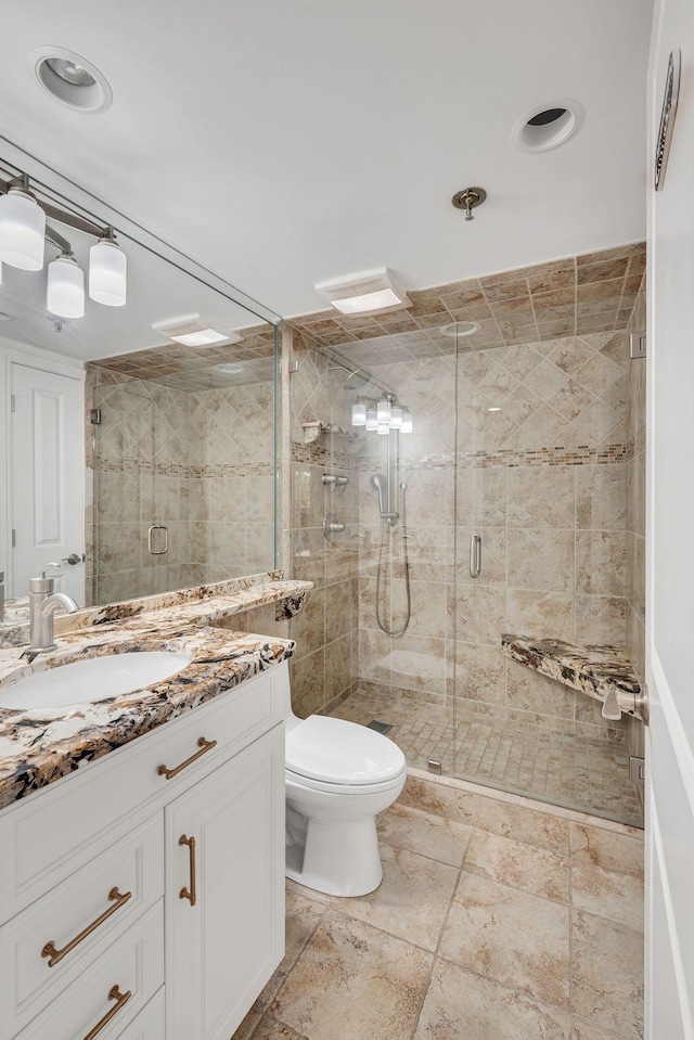 bathroom with vanity, toilet, and a shower with door