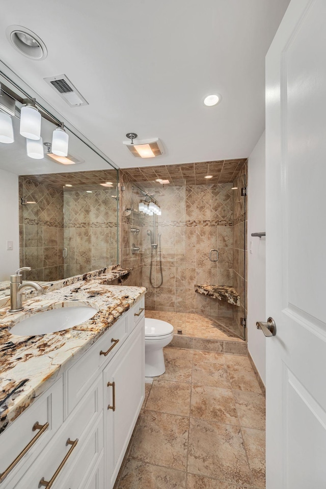 bathroom with vanity, an enclosed shower, and toilet