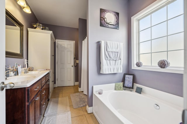 bathroom with double vanity, a wealth of natural light, a bath, and tile patterned floors