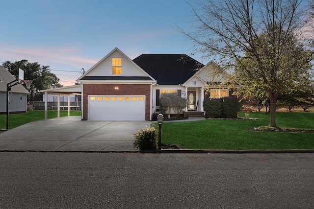 view of front of house with a yard, concrete driveway, brick siding, and a garage