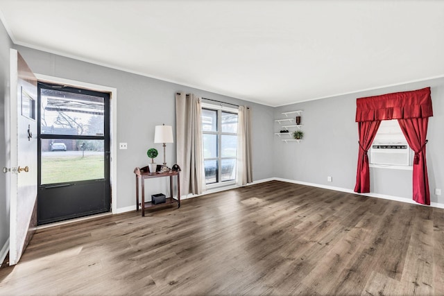 interior space with hardwood / wood-style floors, cooling unit, and ornamental molding