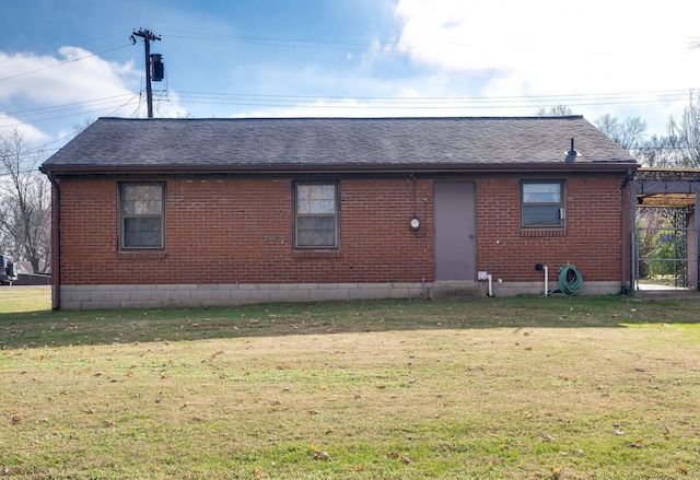 rear view of property featuring a lawn