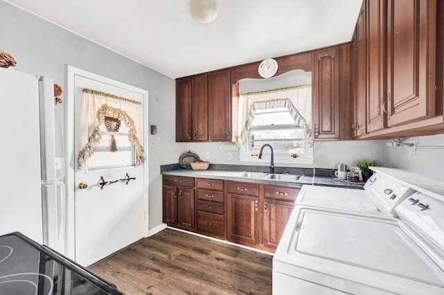 kitchen featuring sink, dark hardwood / wood-style floors, stove, white fridge, and washer and clothes dryer