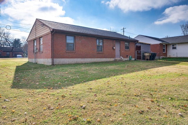 rear view of property featuring a lawn